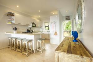 a kitchen with a wooden table and stools at Campismo Ninho 41 in Ponta Malongane