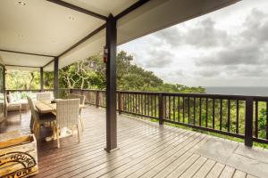 a deck with a table and chairs and the ocean at Campismo Ninho 41 in Ponta Malongane