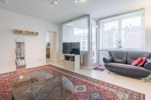 sala de estar con sofá y mesa de cristal en Private Rooms en Hannover