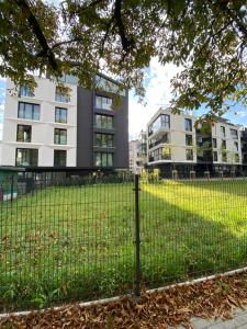 a fence in a park with buildings in the background at Industrial Vistula Apartment Free Parking in Kraków