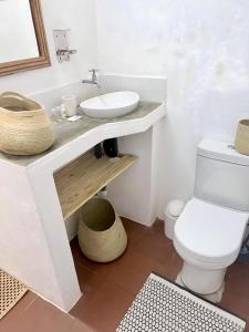 a white bathroom with a sink and a toilet at Blu at tofo in Praia do Tofo
