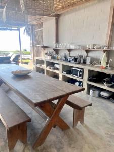 a large kitchen with a wooden table and benches at Blu at tofo in Praia do Tofo