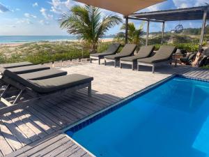 a swimming pool with lounge chairs and the beach at Blu at tofo in Praia do Tofo