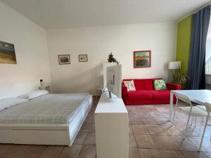 a bedroom with a bed and a red couch at Gens Julia in Rome