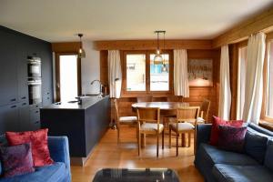 een keuken en een woonkamer met een tafel en een bank bij Tayannes 016 in Verbier