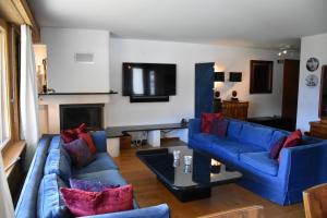 een woonkamer met twee blauwe banken en een tv bij Tayannes 016 in Verbier