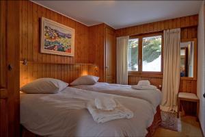 - une chambre avec 2 lits et une fenêtre dans l'établissement Tayannes 016, à Verbier