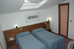 een slaapkamer met 2 blauwe bedden in een kamer bij Hotel Giardino in Prato