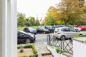 een stel auto's geparkeerd op een parkeerplaats bij 20 Montpellier Flat 2 in Cheltenham