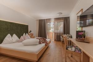 a hotel room with a bed and a desk at Sport & Familienhotel Bärenwirt in Aich +94 photos