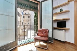 a leather chair sitting in front of a window at Apartament Sant Feliu in Girona