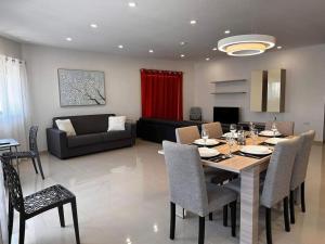comedor y sala de estar con mesa y sillas en Cozy, Spacious 3 Bedroom Maisonette, 6 to 9 ppl, 1 min walk from Seafront, en Marsaxlokk