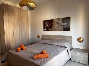 ein Schlafzimmer mit einem Bett mit orangefarbenen Handtüchern darauf in der Unterkunft Cozy, Spacious 3 Bedroom Maisonette, 6 to 9 ppl, 1 min walk from Seafront in Marsaxlokk
