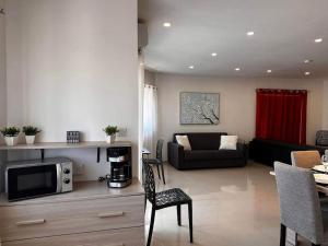 ein Wohnzimmer mit einem Sofa und einem TV in der Unterkunft Cozy, Spacious 3 Bedroom Maisonette, 6 to 9 ppl, 1 min walk from Seafront in Marsaxlokk