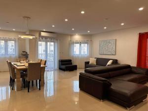 sala de estar con sofá y mesa en Cozy, Spacious 3 Bedroom Maisonette, 6 to 9 ppl, 1 min walk from Seafront, en Marsaxlokk