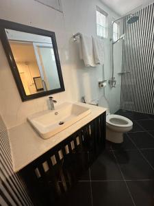 Un baño con lavabo, inodoro y espejo. en Downtown Hostel, en Luang Prabang 12 fotos más