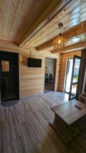 ein Wohnzimmer mit Holzwänden und einem Flachbild-TV in der Unterkunft Taripiri in Ambrolauri