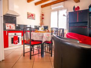 a kitchen with red cabinets and a table with chairs at Maison de vacances in Bompas