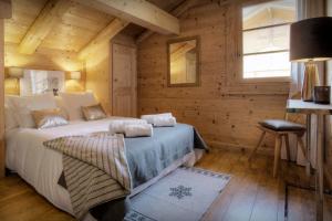 um quarto com uma cama num chalé de madeira em Chalet Hollygotty - OVO Network em La Clusaz