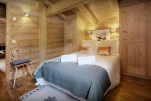 um quarto com uma cama grande num quarto de madeira em Chalet Hollygotty - OVO Network em La Clusaz