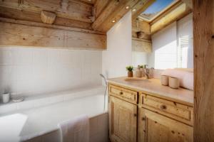 a bathroom with a bath tub and a sink at Chalet Hollygotty - OVO Network in La Clusaz