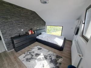 a bedroom with a bed and a brick wall at Casa 3 Catei Veseli in Seciu +51 photos