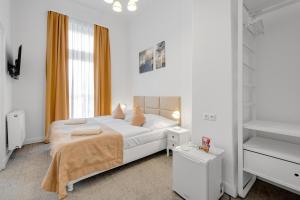 a white bedroom with a bed and a window at Downtown Bratislava B&B in Bratislava