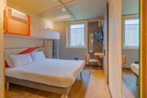 Ibis Budget Lyon Est Saint Quentin Fallavier في سان كانتان فالافييه: غرفة نوم مع سرير وسرير بطابقين