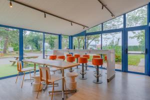 a conference room with tables and chairs and windows at Ibis Budget Lyon Est Saint Quentin Fallavier in Saint-Quentin-Fallavier