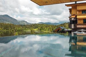 a large pool of water in front of a building at Alpenhotel Kitzbühel am Schwarzsee - 4 Sterne Superior in Kitzbühel