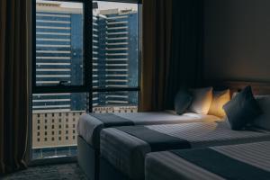 a hotel room with two beds and a large window at Anan Hotel By Snood in Makkah