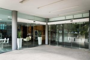 ein Bürogebäude mit Glastüren, Tischen und Stühlen in der Unterkunft AS Porta de Barcelona in Castellbisbal