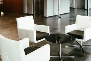 een groep witte stoelen en een tafel in een kamer bij AS Porta de Barcelona in Castellbisbal