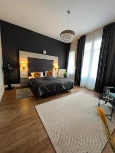 a bedroom with a large bed and a black wall at Denner Hotel in Heidelberg