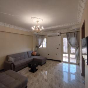 - un salon avec un canapé et un lustre dans l'établissement Apartment Nasr City, au Caire