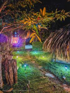einen Garten mit einer Laterne und Licht im Gras in der Unterkunft Hasthi Safari Cottage in Udawalawe