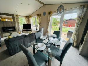 a living room with a glass table and chairs at Bella Rose Lodge with Hot Tub in Malton