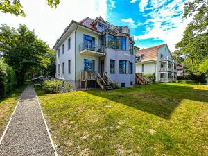 einen Blick auf ein weißes Haus mit einem Hof in der Unterkunft Villa Triton Wohnung 02 in Boltenhagen