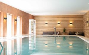 a swimming pool in a house with a wooden wall at Bernstein Schlosshotel Ballenstedt in Ballenstedt