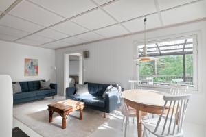 a living room with a blue couch and a table at Family Holiday Home in Ingarö in Enkärret