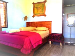 a bedroom with a large bed with a red blanket at Ariel Bungalow Tetebatu in Tetebatu