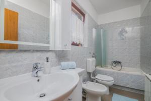 a white bathroom with a sink and a toilet at Marina Porat in Porat +10 photos