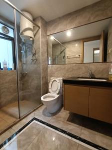 La salle de bains est pourvue de toilettes, d'un lavabo et d'une douche. dans l'établissement R&F princess cove premium home stay 3bed 2bath, à Johor Bahru