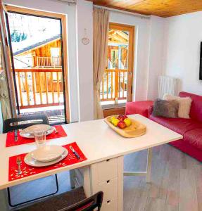 a kitchen with a table with a bowl of fruit on it at Alta Luce Mountain Lodge in Gressoney-la-Trinité