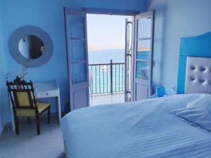 um quarto com uma cama e vista para o oceano em MasouriBlu Boutique Hotel em Masouri