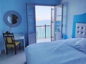 a bedroom with a bed and a view of the ocean at MasouriBlu Boutique Hotel in Masouri