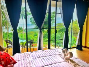 瑤海灘的住宿－Sea View - Palm Villa，卧室设有一张位于大窗户前的床铺。