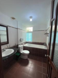a bathroom with a tub and a toilet and a sink at Hotel Nam Sơn in Hai Phong +27 photos