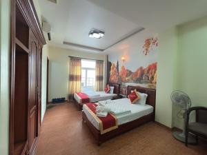 a bedroom with two beds and a painting on the wall at Hotel Nam Sơn in Hai Phong