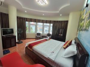 a bedroom with a large bed and a television at Hotel Nam Sơn in Hai Phong